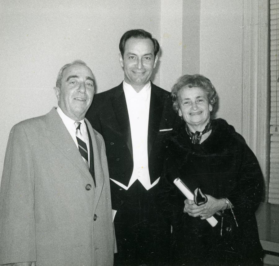 Man in tuxedo flanked by an older man and woman