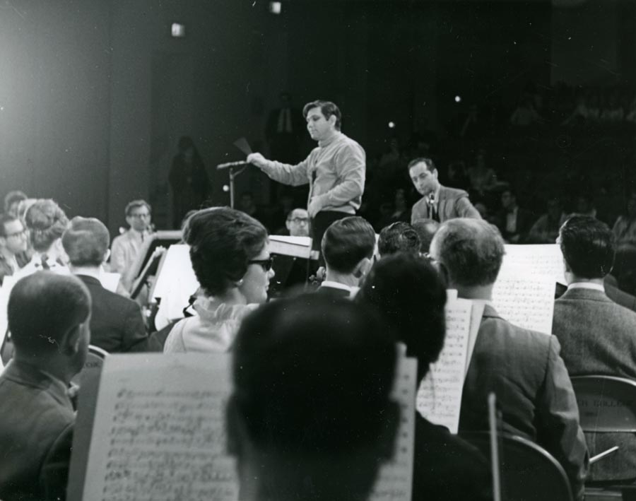 Sitting musicians facing two men