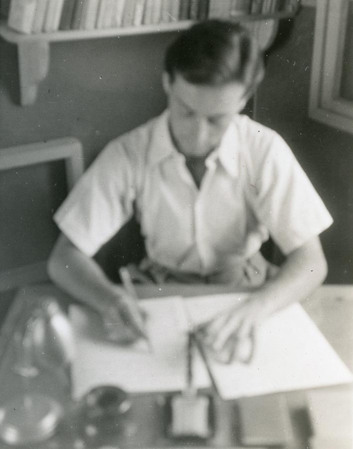Blurry photo of young man writing at desk