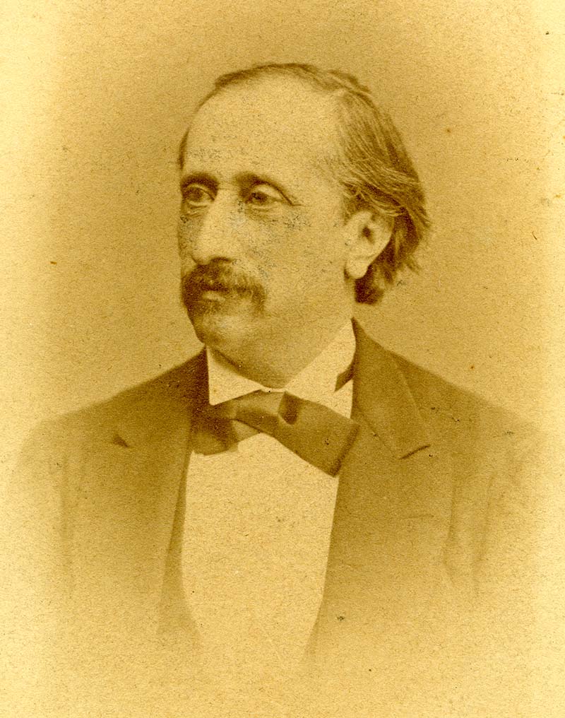 Adolf Brandeis wearing a necktie and blazer, while looking into the distance (sepia-colored photograph)
