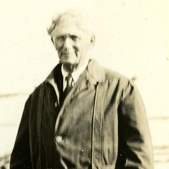 Louid D. Brandeis standing outside as he holds a hat