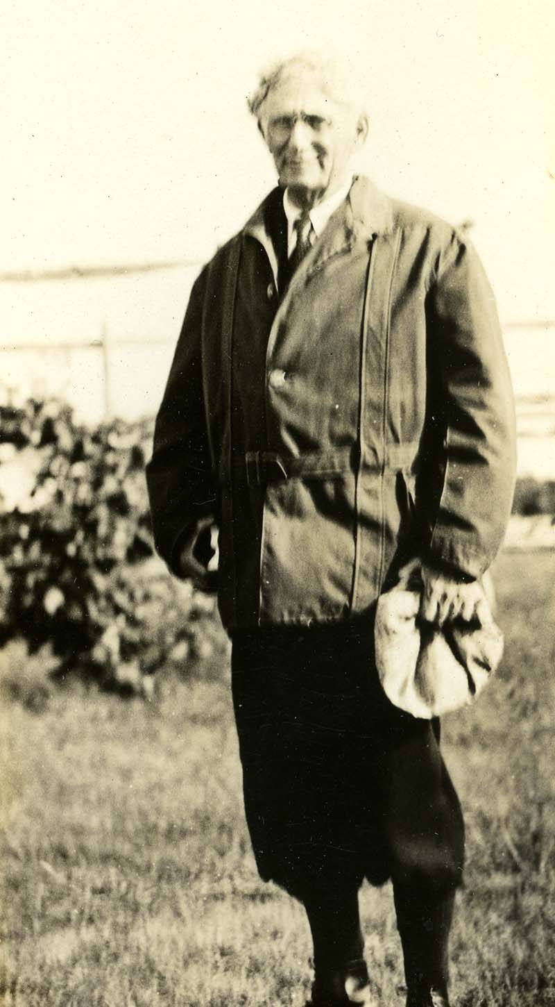 Louid D. Brandeis standing outside as he holds a hat