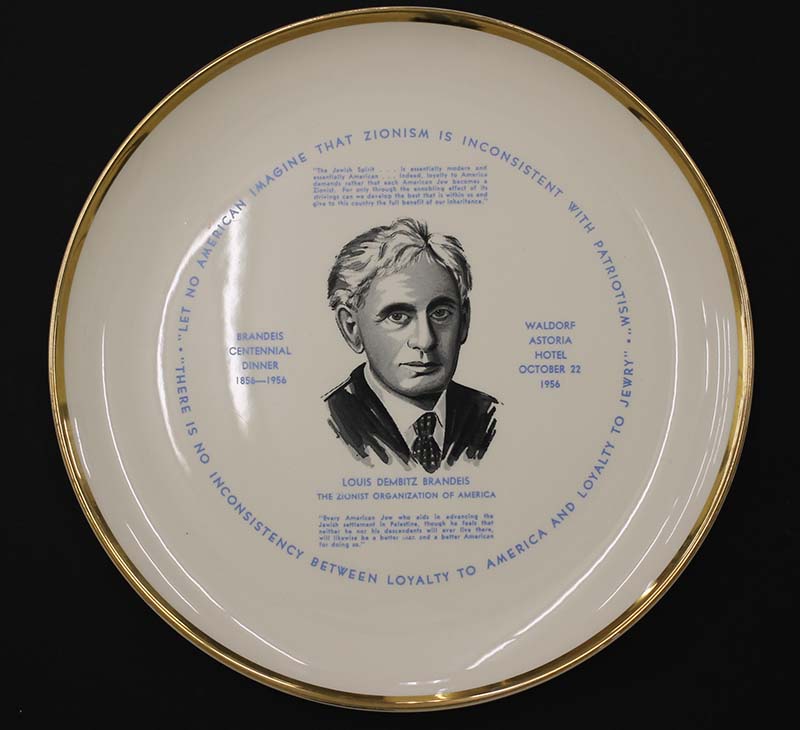 Gold-rimmed decorative plate with an illustration of Louis D. Brandeis (black and white) and his zionism-related quotes. Created by The Zionist Organization of America on October 22, 1956.