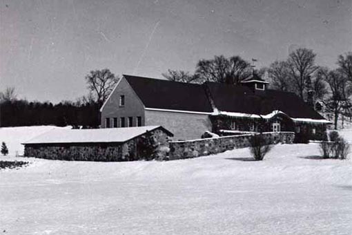 Black and white photograph of the original library building in snow.