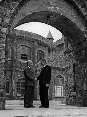 Dr. Sachar Greeting Rabbi Stephen Wise in front of the Castle, framed by an archway, the two men facing each other and shaking hands.