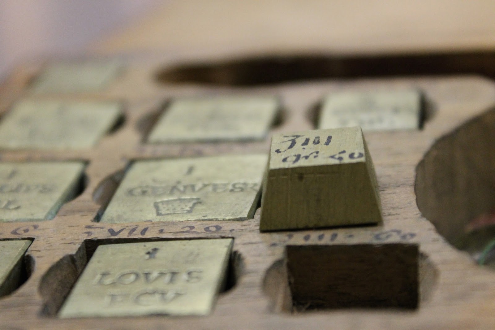 a set of coin weights in the shape of truncated pyramids, each of which is inscribed with something to indicate the coin whose weight they represented