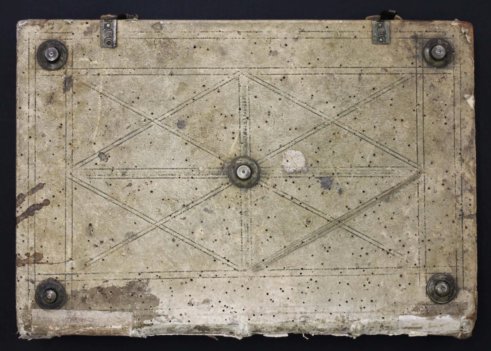 The outside worn leather cover of the book with metal fasteners and 2 buckles