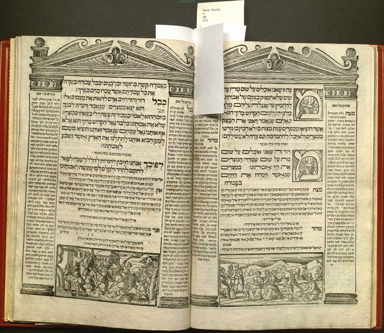 Haggadah open to show two pages of core Hebrew text flanked by commentary in Ladino. Woodcut illustration frames the text on each page as Classical-style buildings, with pediment and columns; Additional woodblock illustrations include historiated initials and scenes from the Haggadah.