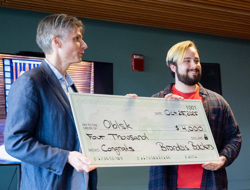 Student receiving large check from a man.
