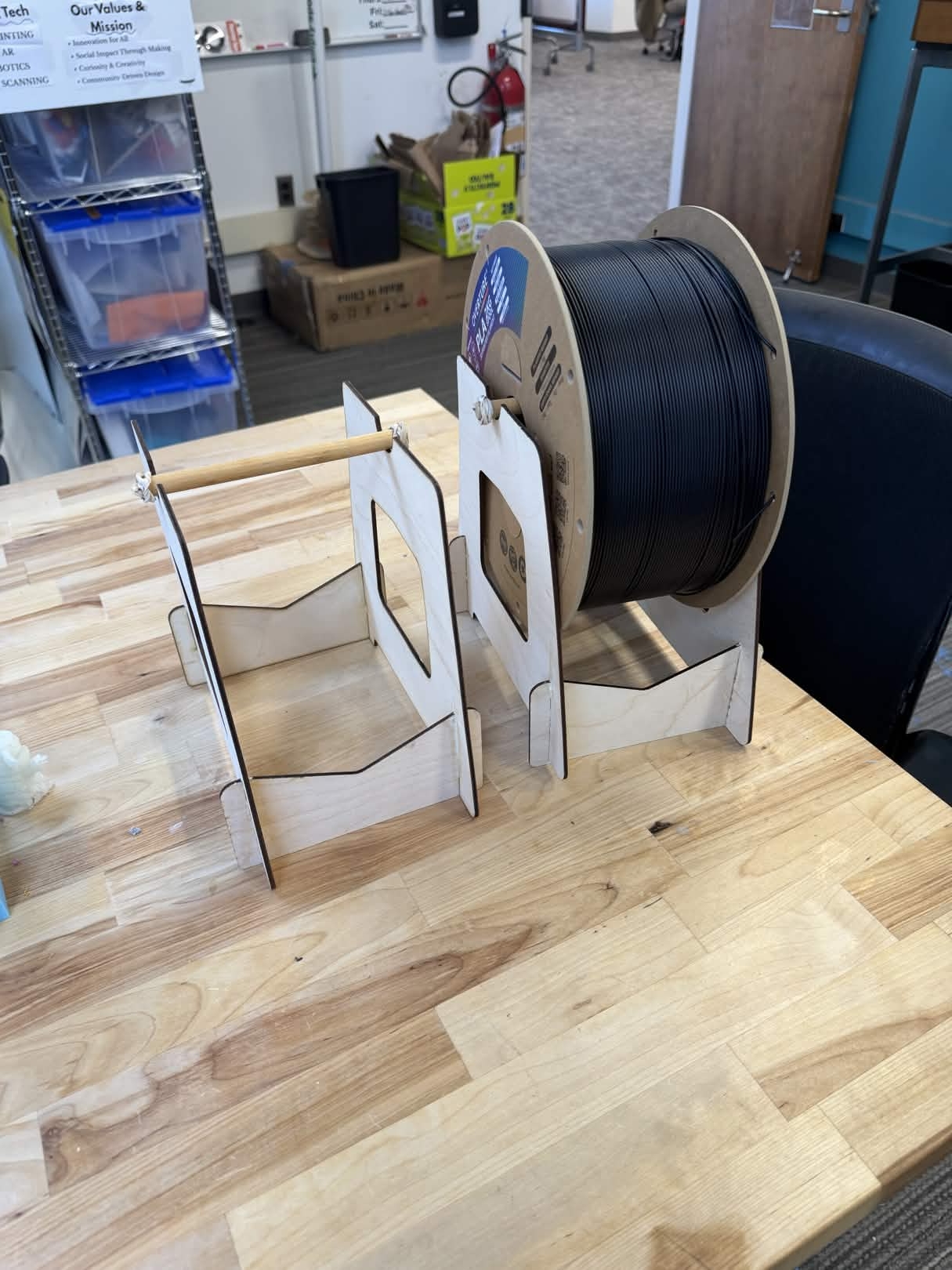 wood frame with a large spool of plastic filament