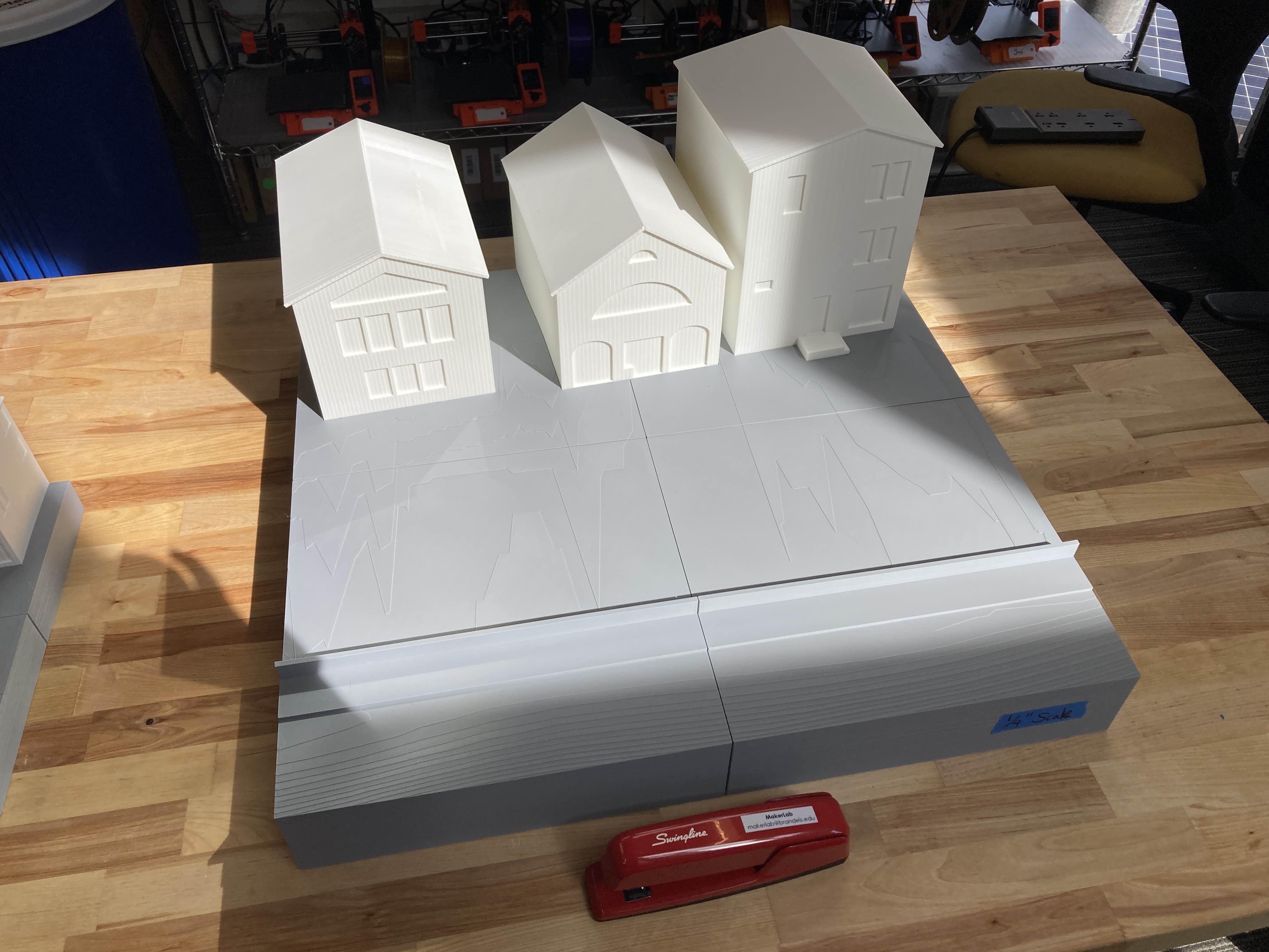 Three model buildings on a topographic model. 