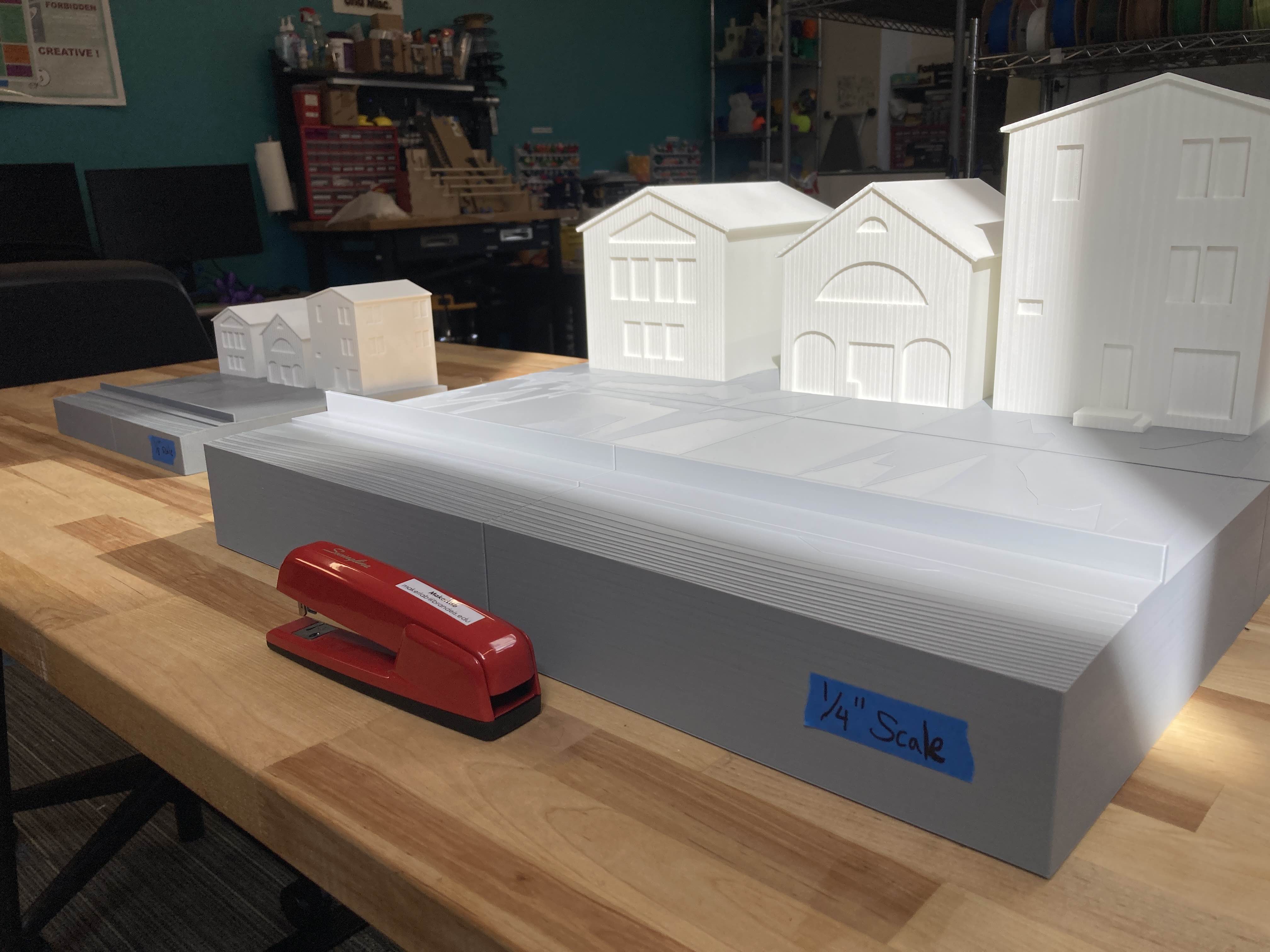 Three model buildings on a topographic model. 