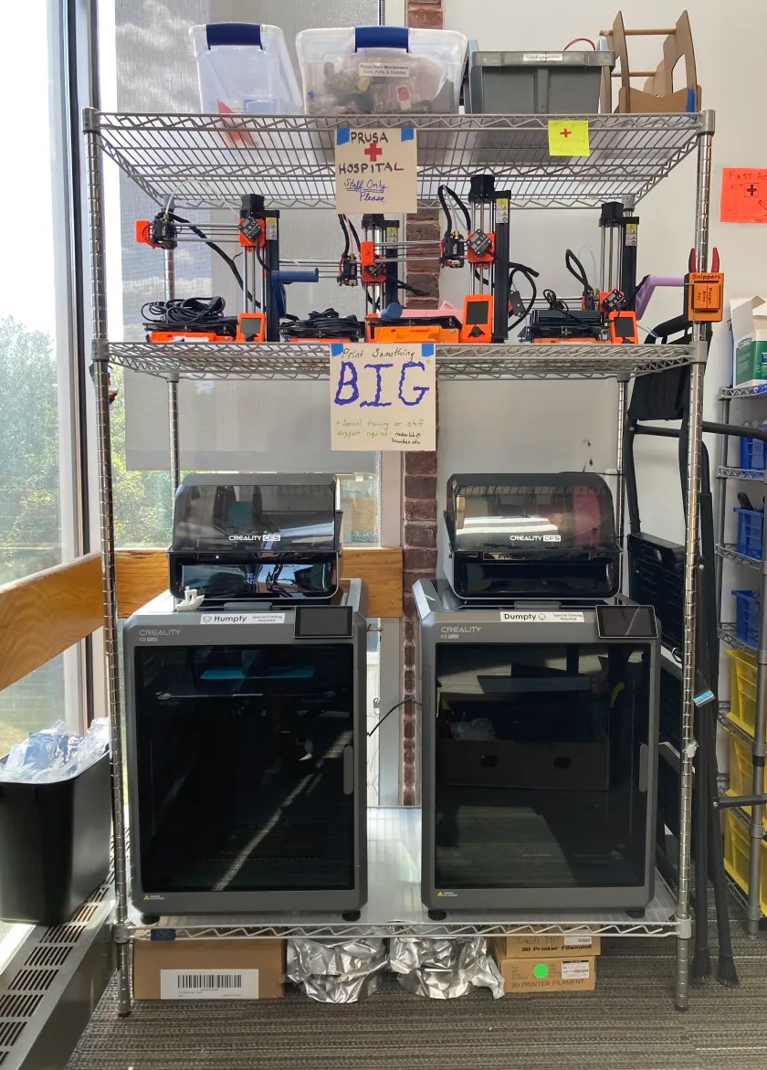 Two 3D printers on a rack.