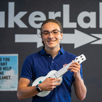 Vincent holding up a 3D printed ukulele.
