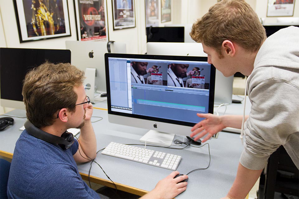 Person getting help while editing a video on a computer