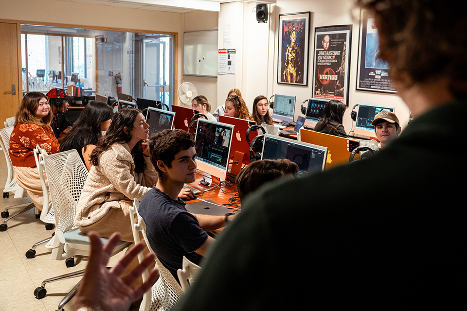 Instructor teaches to a group of students in a computer lab