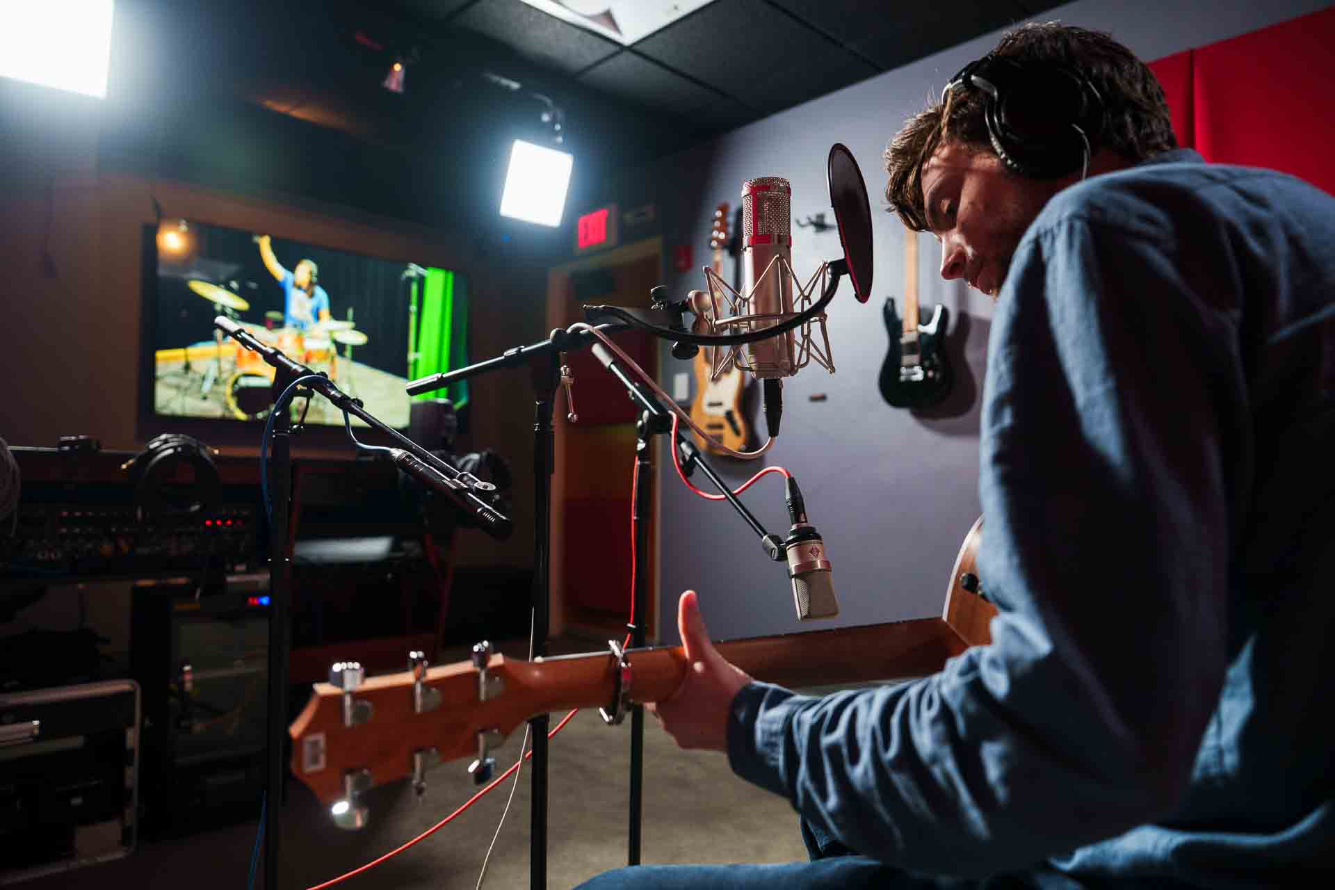 playing guitar in a recording studio