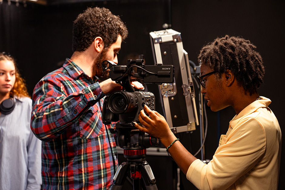 Three students setting up a camera