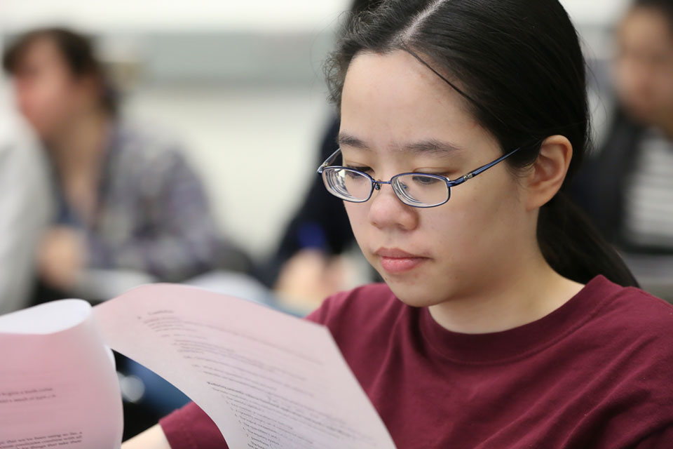 A student looks closely at a packet of paper