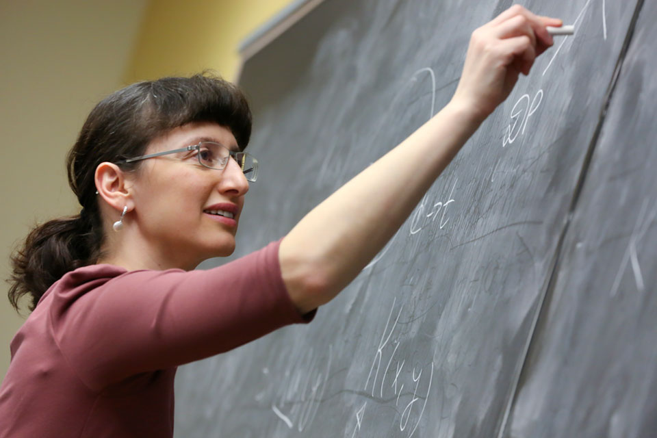 Professor Sophia Malamud writes on a chalkboard