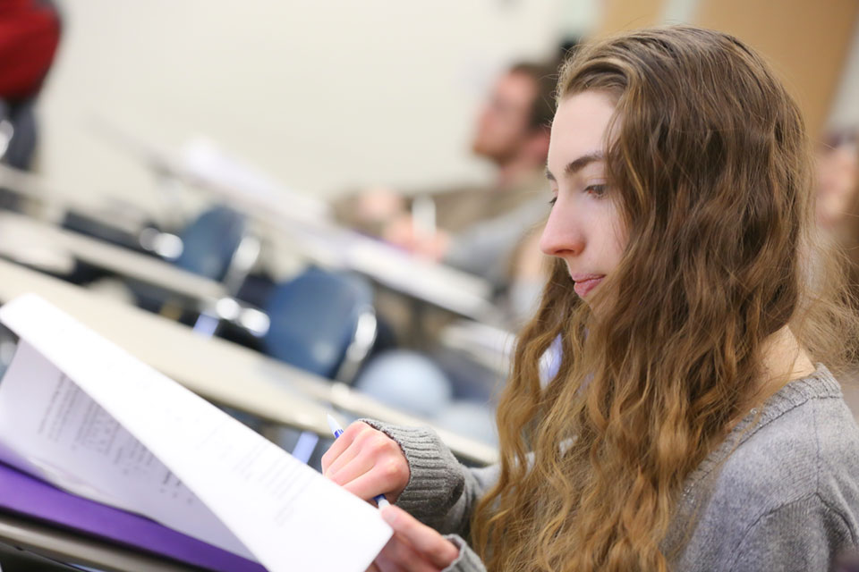 A student looks at paper on a desk