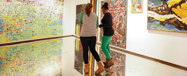 Visitors walk across Beshy's mirror floor in front of the recently acquired "Father, You Have Murdered Me" (at left).