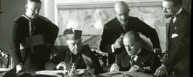 ENDING THE ENMITY: Cardinal Secretary of State Pietro Gasparri and Mussolini sign the Lateran Accords, Feb. 11, 1929.