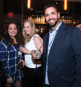 Photo of Nelson Figueroa and two alumnae at holiday party in NYC