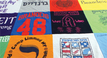 Photo of a quilt made from T-shirts, many of which have a Brandeis connection.