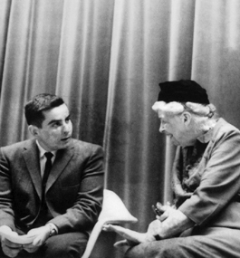 Alan Rubin and Eleanor Roosevelt, seated side by side, chat with each other.