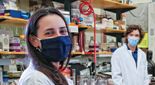 Photo of three people wearing face masks, standing in a laboratory