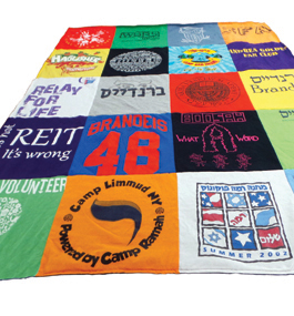 Photo of a quilt made from T-shirts, many of which have a Brandeis connection.