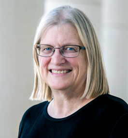 Head shot of a woman with shoulder-length light-colored hair, parted in the middle.