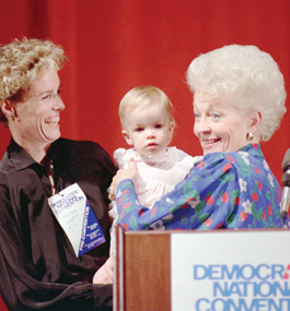 Ann Richards holds baby Lily at a podium, with Cecile Richards smiling broadly beside them.