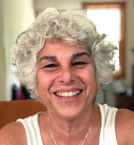 Head shot of smiling woman with curly white-gray hair.