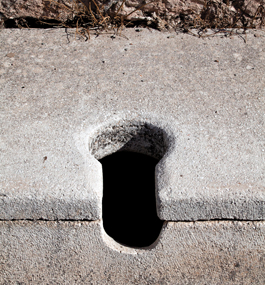Photo of a single hole at an ancient Roman public-toilet site.
