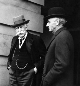 A black-and-white photo of Louis Brandeis and Oliver Wendell Holmes Jr., both wearing fashionable hats of the time.