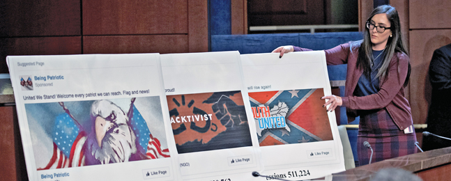 A woman sets up three colorful poster-board displays of individual social-media posts.