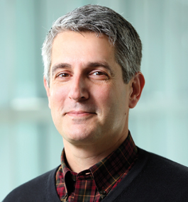 Smiling head shot of a gray-haired man