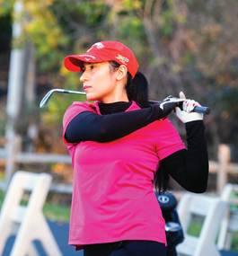 Photo of a young woman dressed in hot-pink and black athletic gear with a golf club resting above her shoulder after making a swing