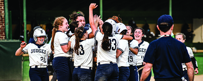 A group of young women in blue-and-white Judges uniforms celebrate.