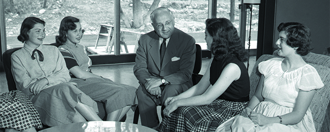 A black-and-shite photo of President Sachar talking with four female students
