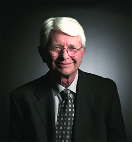 Headshot of a smiling man with white hair