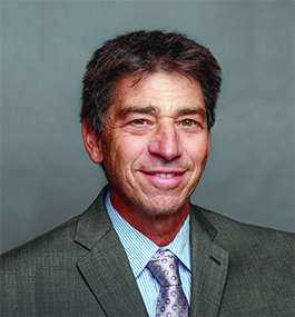 Headshot of a smiling brown-haired man