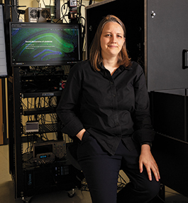 Photo portrait of Christine Grienberger, seated in front of a computer monitor.