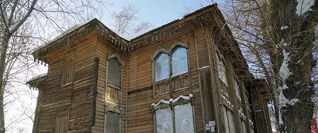 Photo of the exterior of an old building with ornate wood-shingle details.