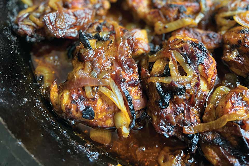 Browned and crispy chicken thighs and onions in a black cast-iron skillet