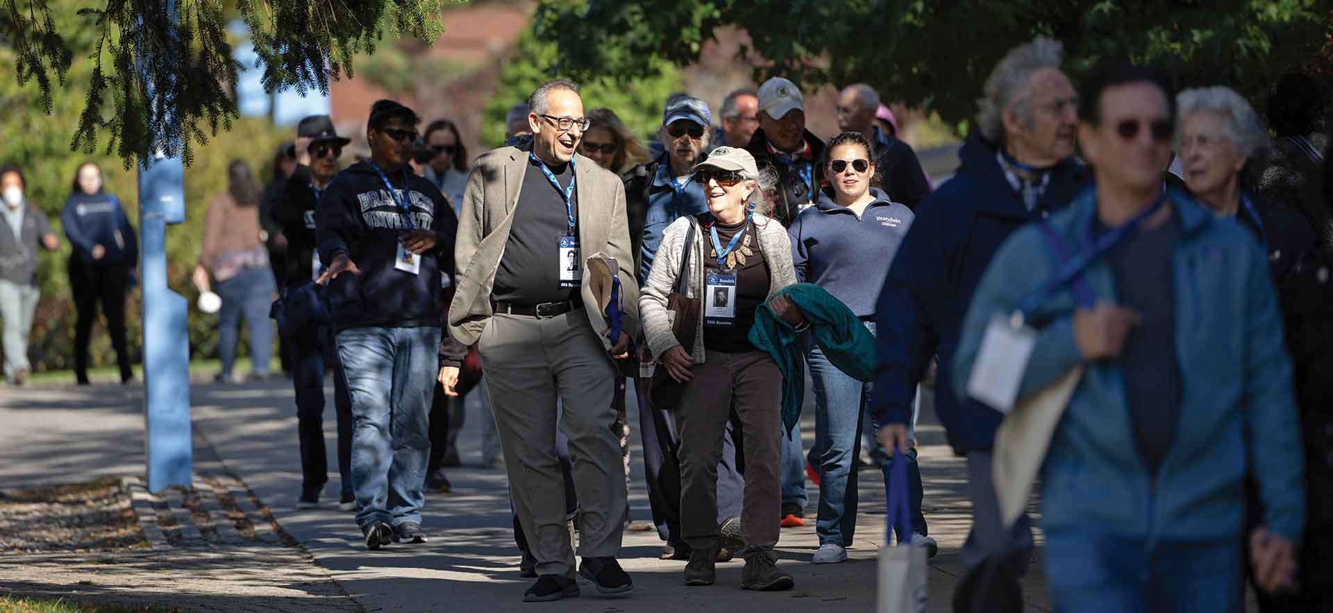 Group of alumni walk through campus on a fall day