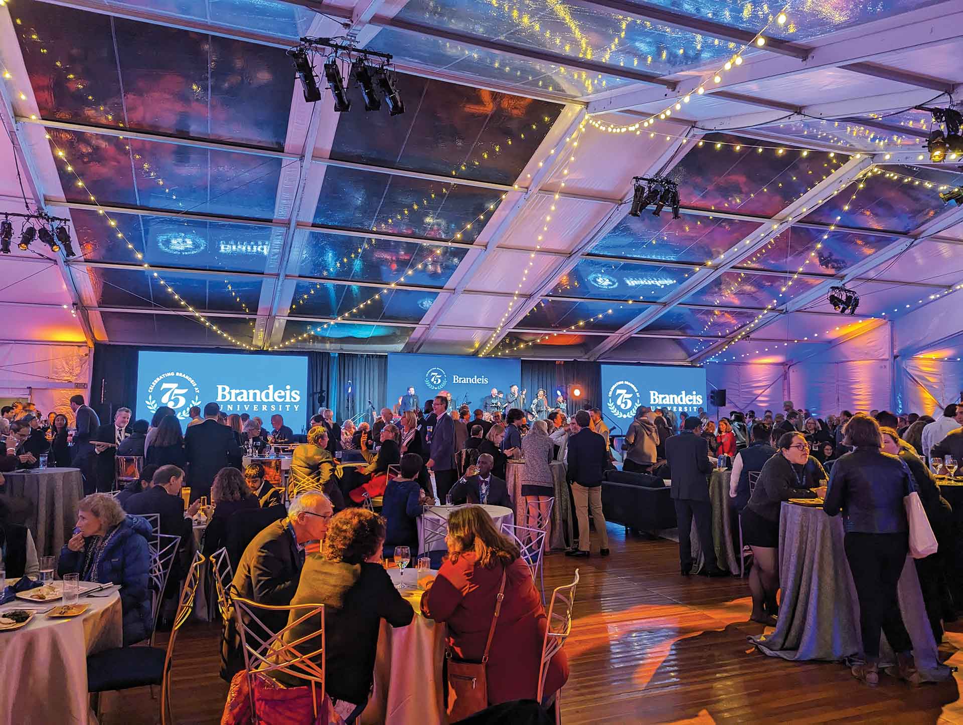 People celebrate the 75th Anniversary under a tent