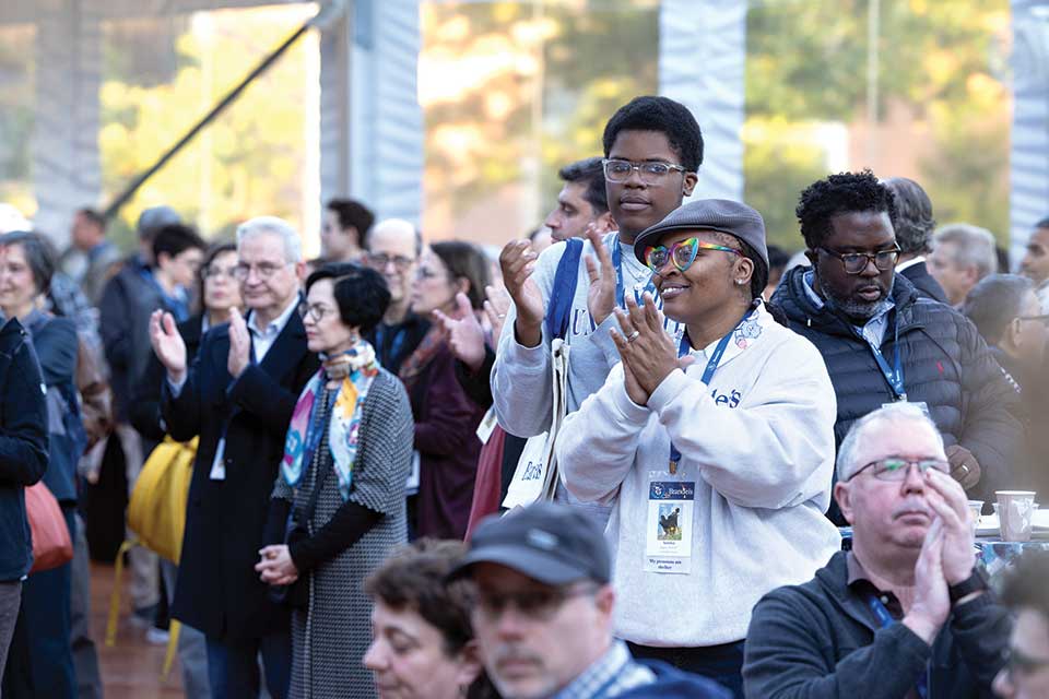 People clap during the welcome celebration